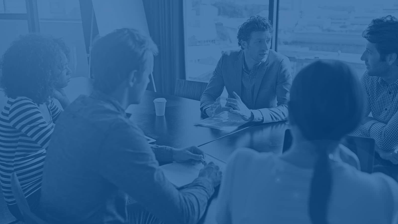 Diverse business team collaborating around conference table in modern office with city view Diverse business team collaborating around conference table in modern office with city view